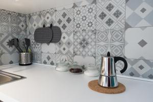 拉古萨Aquila Sveva Domus的厨房柜台配有茶壶和瓷砖