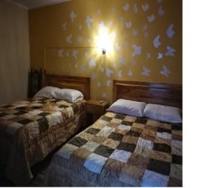 苏克雷Mi Angeline的两张床位于酒店客房,墙上有鸟类