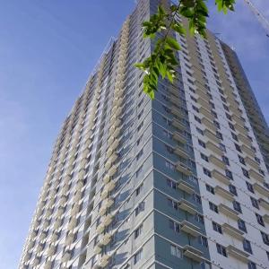 宿务Cozy on the 28th! IT Park Cebu City的一座高大的公寓楼,后面有蓝色的天空