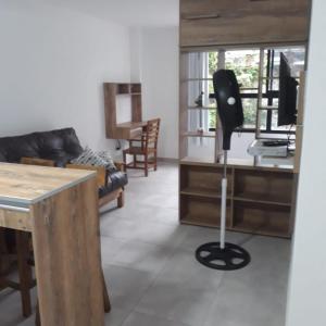 拉普拉塔Depto Temporario La Plata的客厅配有黑椅和书桌