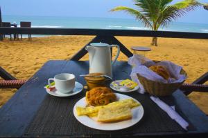 洛美马迪巴公寓式酒店的海滩上一张桌子和一盘食物