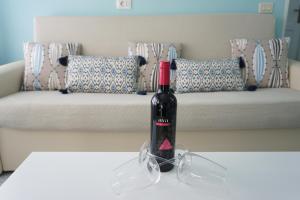 特尔德Bright flat in Salinetas Beach的坐在沙发前的桌子上,一瓶葡萄酒