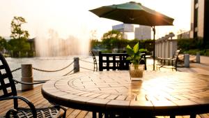 德清Crowne Plaza Deqing Moganshan, an IHG Hotel的木桌,带盆栽和雨伞