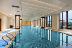 合肥合肥融侨皇冠假日酒店的一个带玻璃地板和窗户的大型游泳池