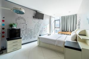 曼谷The Secret Service Bed & Breakfast的一间卧室配有一张床,墙上配有电视