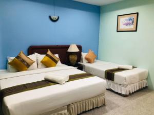 北标府A.K. Terrace Hotel的蓝色墙壁客房的两张床