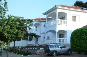 坎帕拉Muyenga Luxury Vacation Home的停在白色房子前面的汽车