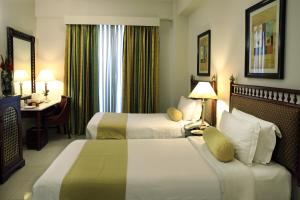 拉瓦尔品第Avari Xpress, Islamabad的酒店客房配有两张床和一张书桌