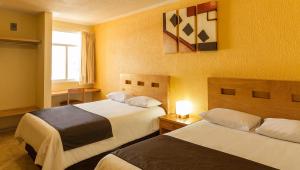 Texcoco de MoraHotel Posada Santa Bertha的酒店客房设有两张床和窗户。