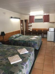 布莱克尔Blackall Coolibah Motel的酒店客房设有两张床和一张桌子。