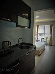 艾登Aydın Kent Suit的一个带水槽的厨房和一张位于客房内的床