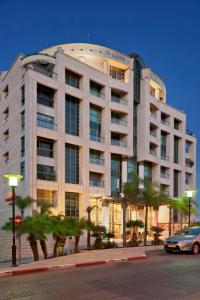 海法Crowne Plaza Haifa, an IHG Hotel的一座棕榈树环绕的大建筑