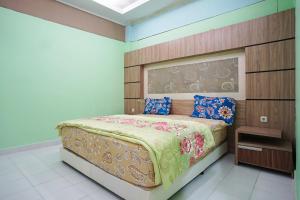 万隆Hotel Bandung Permai的一间卧室配有一张带木制床头板的床