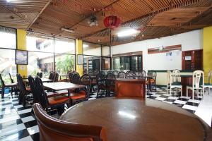 万隆Hotel Bandung Permai的餐厅内带桌椅的用餐室