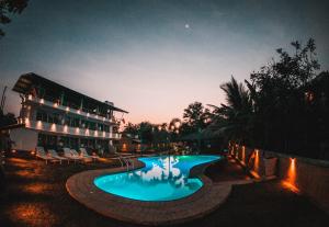 锡吉里亚Royal Rock Sigiriya的一座游泳池,在晚上在建筑物前