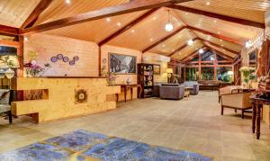 西里古里Treebo Tryst Blue Mountain Country Club And Resort的大型客厅设有木墙和木制天花板