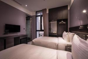 台北艺宿商旅 - 台北 (宁夏馆)的酒店客房设有两张床和电视。