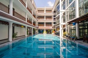 会安Thanh Binh Central Hotel的蓝色建筑中的一个大型游泳池