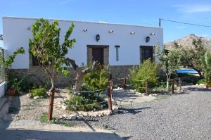 SorbasVilla Garcia - Old Reformed Cortijo的一座有树木的房子,前面有栅栏