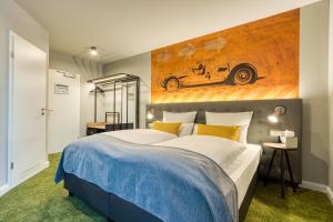 因戈尔施塔特NYCE Hotel Ingolstadt的一间卧室配有一张大床和一幅汽车画