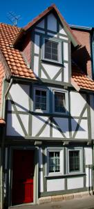 巴特索登-阿伦多夫Mittelalterliches Fachwerkhaus am Diebesturm - klimatisiert-的一间白色和黑色的房子,有红色的门