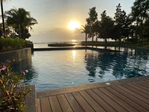 关丹Eyu@Timurbay Seaview Residence的一座享有日落美景的游泳池