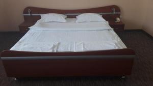 乌日霍罗德宜兹木尔德酒店的一张带白色床单和枕头的床