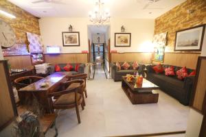 大诺伊达House Of Comfort Greater Noida的带沙发和桌子的客厅以及时钟