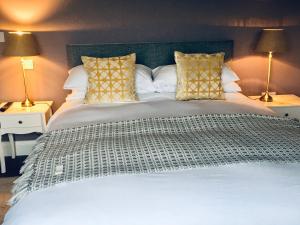 杜林Doolin Village Accomodation的一间卧室配有一张带两盏灯的大型白色床。