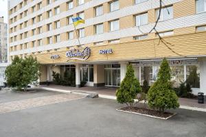 基辅Hotel Druzhba的建筑前方有标志的酒店