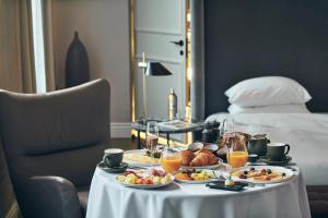 维尔纽斯Hotel Pacai, Vilnius, a Member of Design Hotels的床上的早餐桌,包括食物和饮料