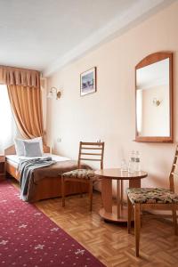 基辅Hotel Druzhba的一间卧室配有一张床、一张桌子和一面镜子
