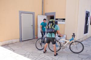 普拉HI Hostel Pula的背着背包站在自行车旁的人