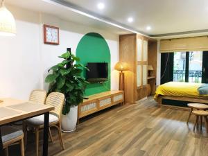 河内Lubi House Homestay的一间卧室配有一张床、一台电视和一张桌子