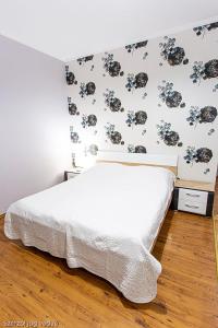 久洛格勒尼巴拉兹斯扎罗公寓的一间卧室配有一张带花卉墙壁的床