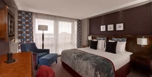 克劳利皇冠假日伦敦盖特威克机场酒店的配有一张床和一把椅子的酒店客房