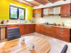 卡隆赫Holiday Home La Tilia by Interhome的厨房配有木制橱柜和木桌。