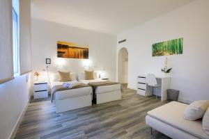 马德里尼奥马格纳马德里酒店的白色的客房配有两张床和一张沙发