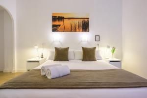 马德里尼奥马格纳马德里酒店的卧室配有一张带两张桌子的大型白色床