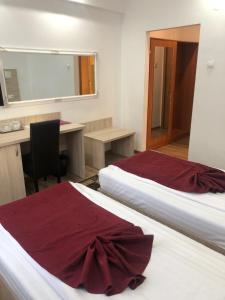 斯拉蒂纳布鲁瓦德名望酒店的酒店客房设有两张床、一张桌子和一面镜子