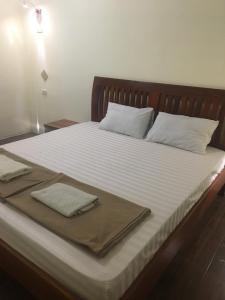 万象梦之家旅馆的一张带白色床单的床和两张毛巾
