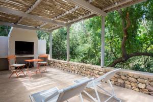 弗朗斯胡克La Chataigne Wines & Guest Cottages的一个带桌椅的庭院和石墙