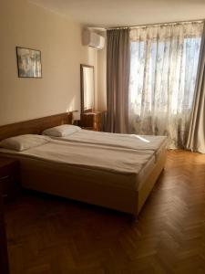 瓦尔纳内什科夫海洋公园酒店的卧室内的一张床铺,设有大窗户