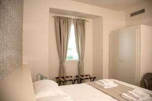 佛罗伦萨Pietrapiana Boutique Apartments的白色的卧室设有床和窗户