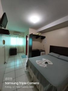 Bom JesusAraguaia Hotel的酒店客房,配有床和电视