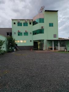 Bom JesusAraguaia Hotel的一座带停车场的大型绿色建筑