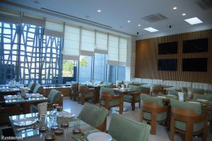 埃尔比勒Hayali Boutique Hotel的用餐室设有桌椅和窗户。