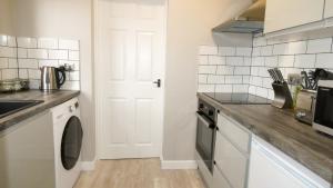特尔福德Flat 2 Castle Street Serviced Apartments的厨房配有水槽和洗衣机