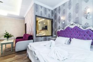 卡尔帕奇Pałac Margot Nature&SPA的卧室配有白色的床和紫色床头板