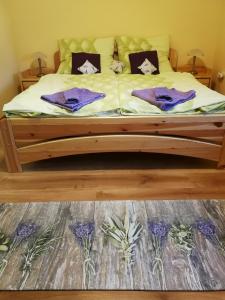 BecsehelyLevendulás ház的一张带紫色床单和枕头的床
